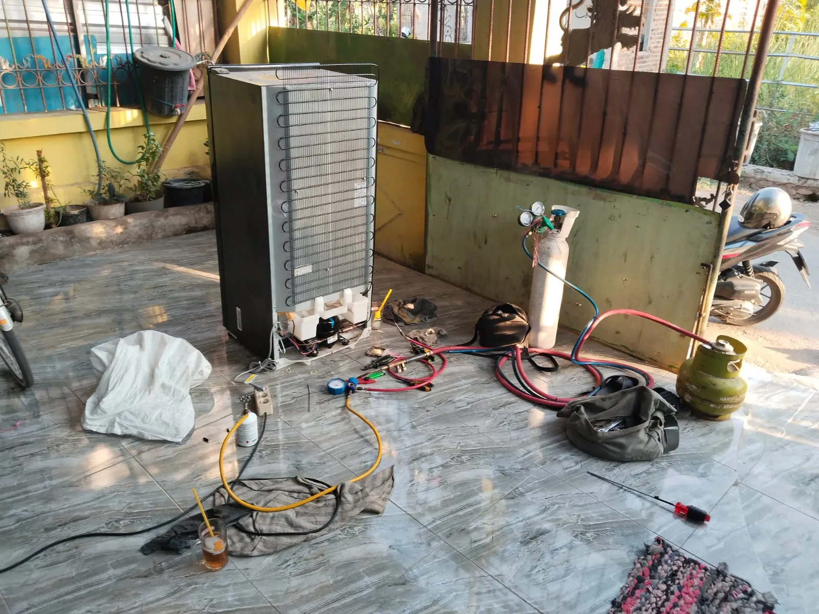 Teknisi Reparasi AC Jombang sedang membersihkan unit AC
